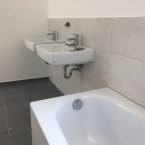 Badezimmer mit Fliesen in grau und Weiß